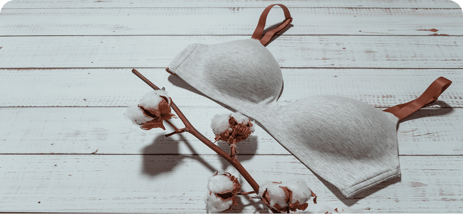 Cotton branch with gray bra on table.